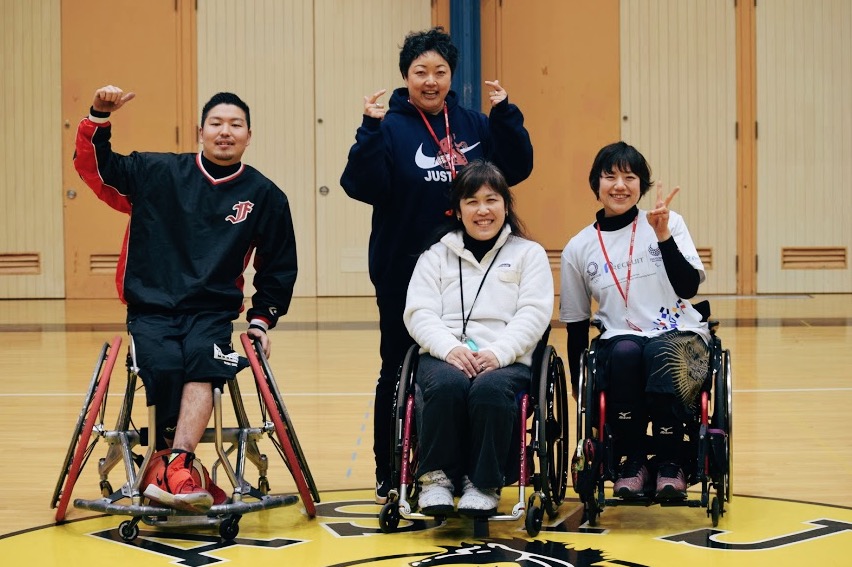 Shinnosuke Moroka, Coach Nagano, Ms. Kyoko Inahara, and Rie Odajima pose after their basketball game with the students.